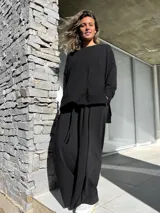 Conjunto negro compuesto por un remerón oversize de mangas largas y un pantalón palazzo de tiro alto con elástico en la cintura.