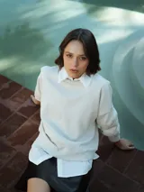 Sudadera color crema de corte holgado, con cuello redondo y mangas largas.