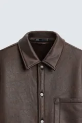 Sobrecamisa marrón de efecto piel con interior de borreguillo a tono, de corte relaxed fit, cuello solapa, manga larga con puños abotonados, bolsillos de plastrón en pecho y laterales, efecto lavado y cierre frontal con botones a presión.