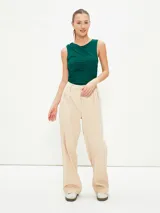 Pantalón gris oscuro de corte amplio, con pinzas en la cintura y bolsillos laterales.