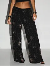 Pantalón palazzo negro con bordados de flores en color dorado.