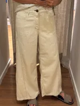 Pantalón ancho color beige, de corte holgado desde la cadera hasta el tobillo.