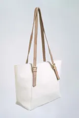 Cartera tipo shopper color negro, con textura símil cuero, doble asa de hombro con hebillas doradas y cierre superior.