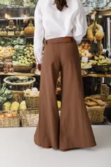 Pantalón de lino color crudo con finas rayas verticales negras, corte wide leg y tiro alto.
