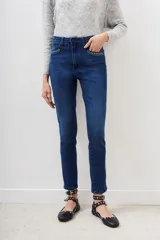 Jean slim de denim azul con lavado localizado y detalles de hot fix en los bolsillos delanteros.