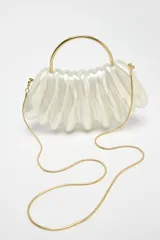 Bolso de mano asimétrico con efecto perlado y asa rígida dorada. Incluye asa de cadena extraíble y cierre magnético.