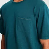 Remera verde azulado de manga corta con bolsillo en el pecho.