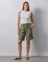 Bermuda de algodón color beige, marca Robert Louis, con pretina ancha elastizada, lazo de ajuste simulado, bolsillos verticales delanteros y bolsillos laterales con botón.