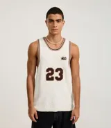 Musculosa de punto color crema con cuello redondo y bies contrastante en marrón. Presenta el número 23 estampado en el frente y un pequeño logo con una estrella.