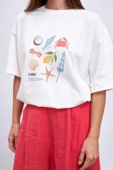 Remera blanca de corte holgado con estampa pequeña en el frente.