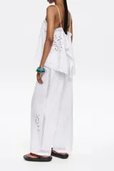 Pantalón blanco de corte ancho con cintura elástica y bordado en la parte inferior de la pierna.