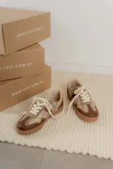 Championes acordonados color beige y dorado con suela marrón.