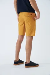 Bermuda de gabardina azul marino con logo bordado, bolsillos laterales y traseros, cierre con cremallera y botón, y presillas para cinturón.