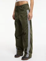 Pantalón slouchy marrón de tiro alto con cierre de botón y cremallera, pretina con pasacinto y rayas blancas laterales.