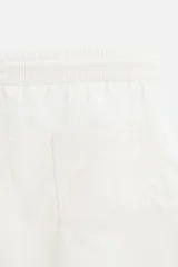 Bañador corto color blanco hueso de tejido técnico, con cintura elástica ajustable con cordón, bolsillos laterales y trasero.