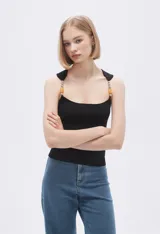 Musculosa celeste de punto canale con cuello recto y tirantes anchos decorados con cuentas de madera.