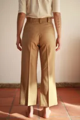 Pantalón de vestir color beige, de paño de lana elastizado, corte palazzo y cintura alta con lazo.