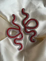 Aros colgantes con forma de serpiente azul contorneada con strass plateado.