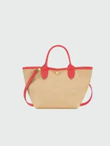 Bolso Longchamp modelo Le Panier Pliage, de paja color beige con detalles en cuero rojo, incluyendo asas y ribetes. Presenta un bordado de un caballo en rojo.