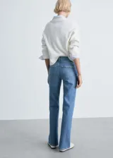 Pantalón de jean azul de corte recto, tiro medio, con cinco bolsillos, trabillas y aberturas en el bajo.