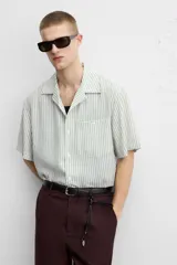 Camisa de hombre relaxed fit con cuello bowling y manga corta, confeccionada en tejido fluido con mezcla de viscosa a rayas verticales en tonos verde y blanco.
