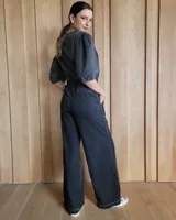 Conjunto de camisa y pantalón de lino blanco. La camisa es de manga larga y se ata en la parte delantera. El pantalón es de corte ancho y tiene cordón en la cintura.