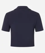 Blusa de punto acanalado (rib) color marrón oscuro, con cuello polo, escote en V y manga corta.