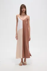 Vestido largo, holgado, con breteles finos y escote en V. Presenta un diseño de bloques de color en tonos blanco, beige claro y marrón.