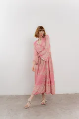 Vestido largo azul con estampado floral en tonos beige, confeccionado en viscosa. Presenta escote en V, botonadura completa en el frente y mangas largas con volados.