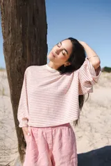 Remera oversize a rayas horizontales color verde claro y blanco, de mangas largas y cuello redondo.