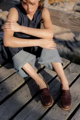 Mocasines de cuero marrón con diseño de cocodrilo, suela plana y detalle de antifaz en el empeine.