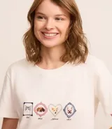 Conjunto de pijama corto compuesto por una remera de algodón blanca con estampado de mascotas y un short de viscosa a cuadros en tonos rosa y beige con volados en el ruedo.