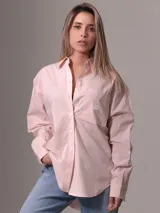 Camisa de popelín de algodón color rosa claro, de corte holgado, con cuello clásico, cierre frontal con botones, bolsillo de parche en el pecho y puños abotonados.
