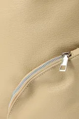 Bandolera color beige con correa ajustable, bolsillo grande y dos bolsillos pequeños frontales con cierre.