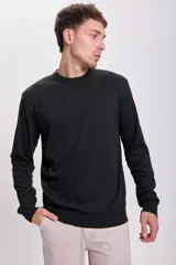 Buzo negro de punto básico con cuello redondo y mangas largas.