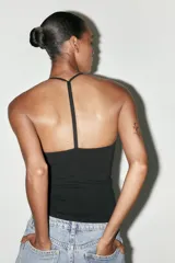 Top negro de cuello halter con escote pico y tiras finas en la espalda.