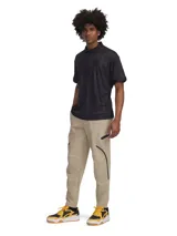 Pantalón de jogging Under Armour para hombre, color beige, con corte ajustado, cintura elástica, bolsillos laterales con cierre y bolsillos cargo con solapa. Logo de la marca en la cadera izquierda. Confeccionado en tejido técnico resistente al agua y elástico.