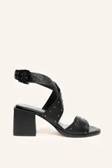 Sandalia de cuero vacuno color negro, con tiras cruzadas con tachas metálicas y taco ancho de 6,5 cm.