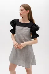 Vestido corto con cuerpo a rayas verticales en tonos beige y blanco, mangas cortas abullonadas y canesú superior en color negro.