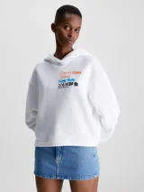 Buzo blanco de corte cropped, con capucha y mangas largas. Estampado frontal con el logo de Calvin Klein Jeans y la frase "New York 205 W39 St" en colores naranja, azul y negro.