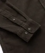 Camisa blanca de manga larga, confeccionada en terciopelo con cuello clásico y bolsillos frontales.