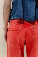 Pantalón de jean azul de pierna ancha y tiro medio, con cinco bolsillos y pespuntes a contratono.