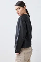 Chaqueta negra de eco cuero calado, con cuello redondo y cierre frontal con botones a presión.