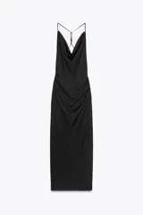 Vestido midi negro de escote fluido y tirantes finos con abalorios en la espalda. Tiene pliegues laterales en la cintura, bajo con abertura en la espalda y cierre lateral con cremallera oculta.
