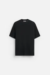 Camiseta negra de punto de algodón, corte recto, cuello redondo y mangas cortas con terminaciones acanaladas.