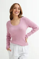 Sweater de punto color rosado con cuello redondo y mangas largas. Tejido de punto acanalado.