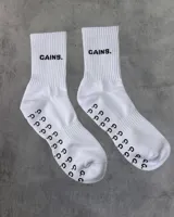 Par de medias deportivas blancas con texto 'GAINS.' en negro y agarre antideslizante con el logo 'G.G.' en la planta del pie.