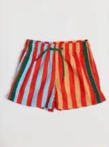 Short de baño azul con cintura elástica, rayas verdes en los laterales y bolsillo trasero con solapa roja y verde.