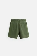 Bermuda negra regular fit confeccionada en tejido con mezcla de algodón y lino. Cintura elástica ajustable con cordón. Pliegues frontales. Bolsillos laterales y traseros de vivo. Cierre frontal con cremallera y botón.
