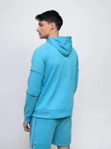 Campera con capucha Umbro de piqué, color gris con mangas negras y logo bordado en blanco.